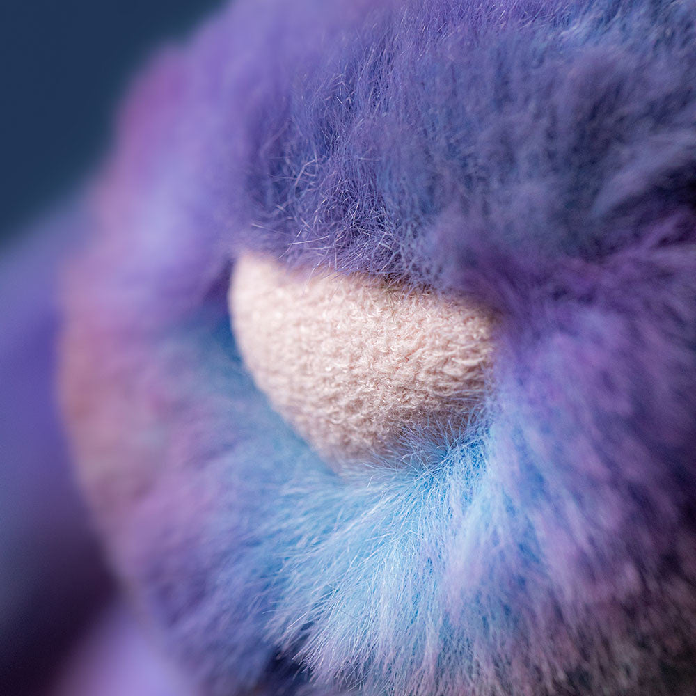 Close-up of the Jellycat Zodihop Luxe Bunny, highlighting its soft, fluffy purple and blue fur with cosmic patterns and a beige textured nose.