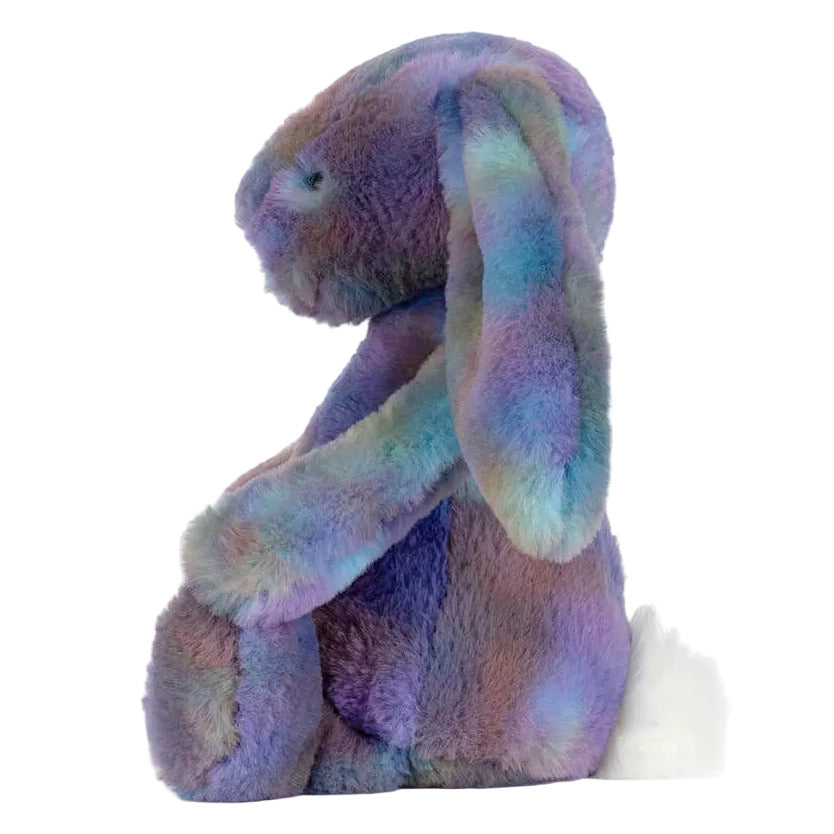 The Jellycat Zodihop Luxe Bunny plush features multicolored pastel fur with a cosmic pattern and a white tail, shown in profile view against a white background.