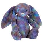 The Jellycat Zodihop Luxe Bunny plush toy features long floppy ears, ultra-soft fur with a cosmic pattern in mottled purple, blue, and green shades, and sits upright.