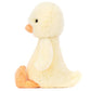 The Jellycat Bashful Duckling plush toy sits upright in side profile on a white background, featuring soft yellow fur and orange beak and feet.