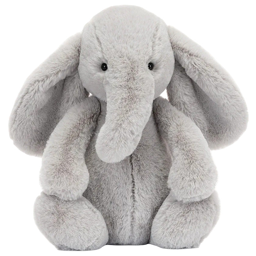 A gray Bashful Luxe Elephant Thuddeus plush by Jellycat with big ears and a long trunk, sitting upright and facing forward.