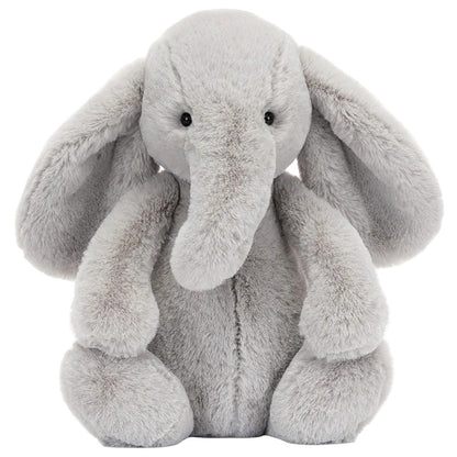 A gray Bashful Luxe Elephant Thuddeus plush by Jellycat with big ears and a long trunk, sitting upright and facing forward.