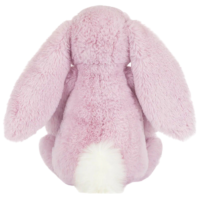 The Jellycat Thistlepop Blossom Luxe Bunny Original features plush pink fur, long floppy ears, and a white tail—an adorable bunny viewed from the back, perfect for gifting with a Rainbow Birthday Cake.