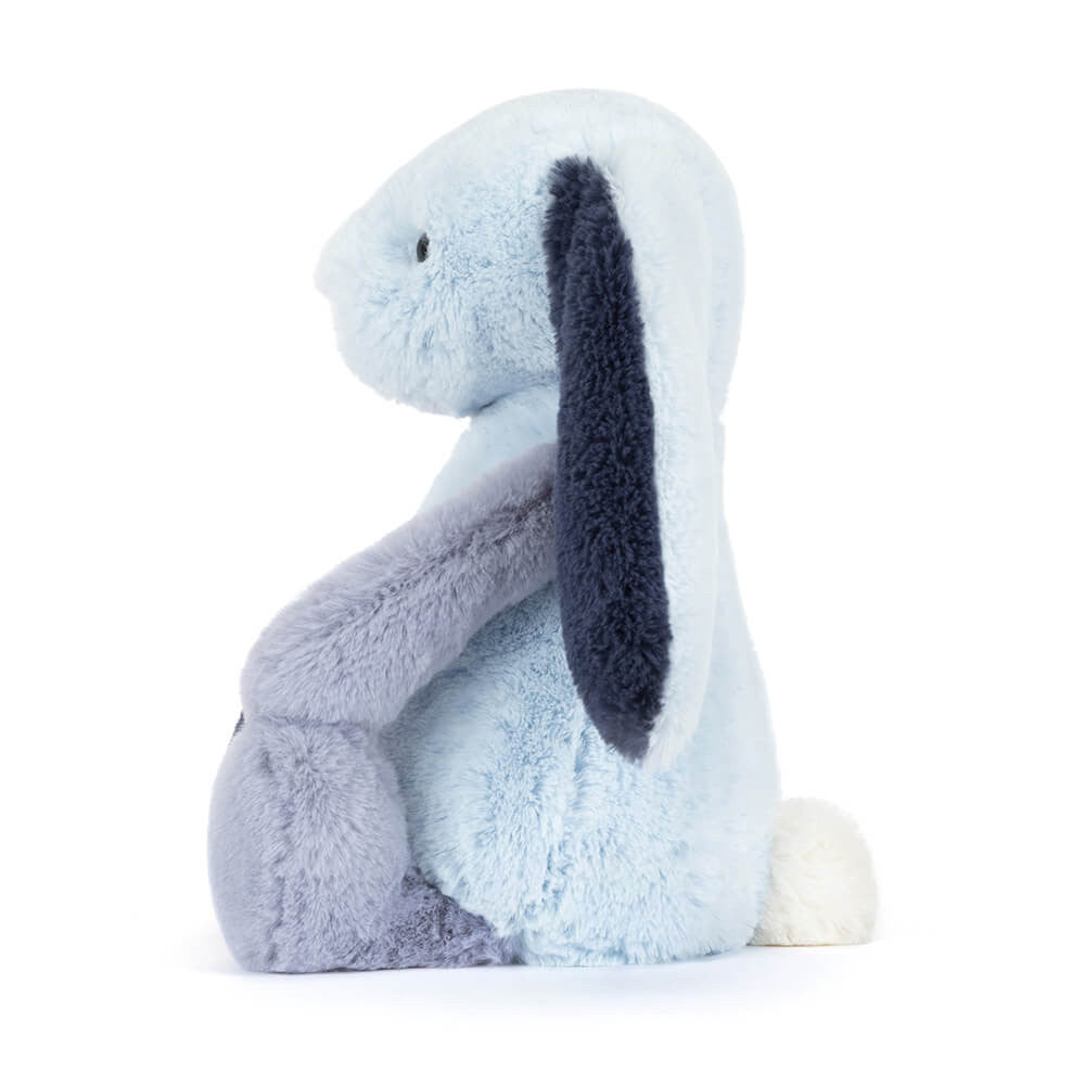 Jellycat’s Puddlesea Bunny features light blue fur, dark blue ears, and a small white tail, shown upright in profile against a white background. Perfect as a creative beach toy or paired with any sandcastle kit.