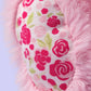 Close-up of a Jellycat Blushkin Blossom Luxe Bunny Original plush toy, showing a pink design and a fabric patch with a red and green floral pattern.