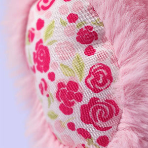 Close-up of a Jellycat Blushkin Blossom Luxe Bunny Original plush toy, showing a pink design and a fabric patch with a red and green floral pattern.