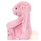 The Blushkin Blossom Luxe Bunny Original by Jellycat sits upright, displaying floral-patterned inner ears and feet, a white fluffy tail, and shiny black eyes.