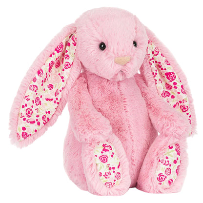 The Jellycat Blushkin Blossom Luxe Bunny Original plush features long floral-patterned ears, matching feet, and a soft pink body, sitting upright.