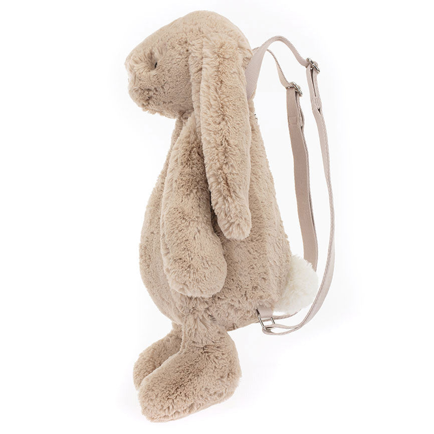 The Jellycat Bashful Beige Bunny Backpack features a fluffy beige design with long ears, a white tail, and comfy adjustable straps.