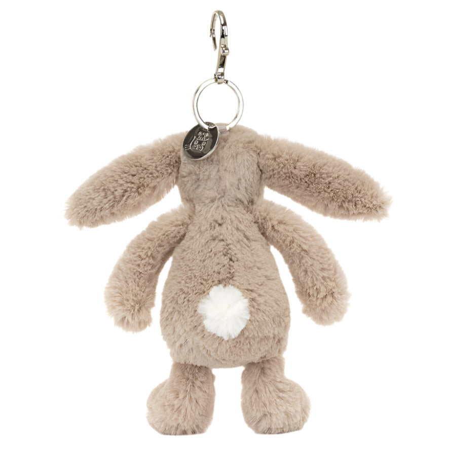 The Jellycat Bashful Beige Bunny Bag Charm is a gray plush rabbit keychain with floppy ears and a white tail, featuring a metal clasp and circular tag, perfect as a whimsical accessory or bag charm.