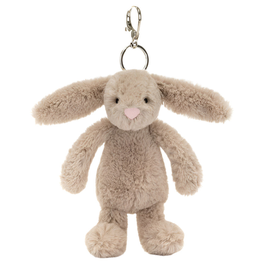 The Jellycat Bashful Beige Bunny Bag Charm by Jellycat is a plush accessory with long ears, a pink nose, and a sturdy metal clasp, ideal as a cute bag charm.