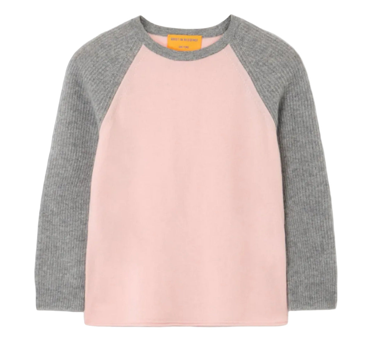 The Guest in Residence Baseball Tee is a lightweight cashmere top with a light pink body and gray colorblock raglan sleeves, shown against a white background.
