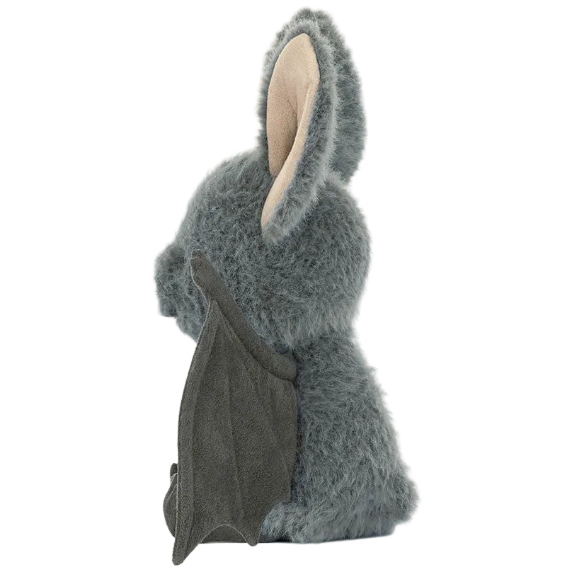 A soft gray plush Broox Bat toy from Jellycat, featuring large ears and small bat-like wings, is pictured in profile facing left.