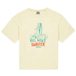 The Boys' Big Wave Livo T-Shirt by Bonton is a pale yellow kids’ summer tee with a cartoon dog and surfboard plus “Big Wave Surfer Bonbon” in green and orange—perfect for playful summer fun.