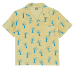 The Boys' Livio Polo, Palmiers by Bonton is a short-sleeve, light yellow 100% cotton shirt with a front pocket and blue palm tree patterns.