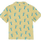The Boys' Livio Polo, Palmiers by Bonton is a yellow short-sleeve 100% cotton shirt with a collar and an all-over blue palm tree print, displayed flat from the back.