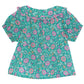 The Baby Girls' Aria Shirt by Bonton is a short-sleeve top featuring a green background with a pink floral pattern and a ruffled Peter Pan collar edged in light trim.