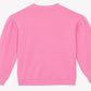 A plain pink long-sleeve sweatshirt from Bonton, the Girls’ Nolwen Sweatshirt, is displayed laid flat and viewed from the back. It features slight gathering at the shoulders, ribbed cuffs and hem, and subtle puffy sleeves for a charming touch.