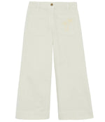 The Bonton Girls' Lakiko Pant features a wide-leg, high-waisted cream design with front patch pockets and a subtle palm tree embroidery on the left pocket.