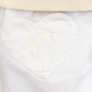 Close-up of a white heart-shaped pocket with embroidered palm trees beneath a beige ribbed waistband adds charm to the ecru Girls' Douchka Skirt by Bonton.