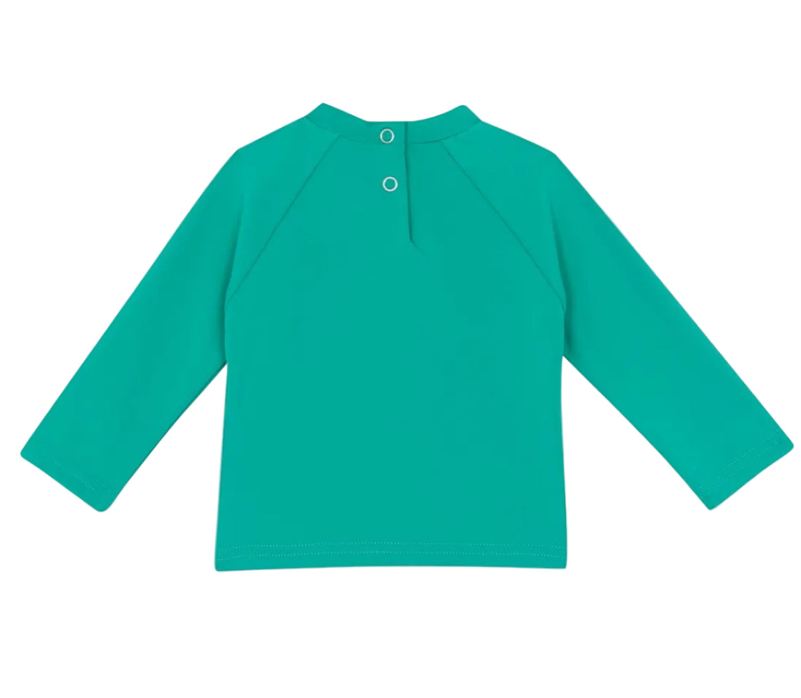 The Bonton Baby Rashguard is a teal kids’ beachwear swim t-shirt with long sleeves, anti-UV protection, and two back snaps at the neckline. Shown laid flat with the back facing up.