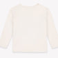 Back view of the Bonton Baby and Toddler Taxi Cool T-Shirt, a plain, long-sleeve, off-white kids’ top made from 100% cotton, laid flat on a white background.