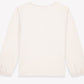 The Girls’ Mermaid Patch T-Shirt by Bonton is pictured from the back, showcasing long sleeves with elastic cuffs and a classic round neckline in an off-white color against a white background.