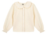 The Girls’ Figue Shirt by Bonton features a cream long-sleeve design with a ruffled Peter Pan collar, button-down front, pleated texture, and lace trim detail.