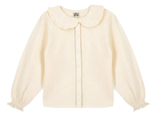 The Girls’ Figue Shirt by Bonton features a cream long-sleeve design with a ruffled Peter Pan collar, button-down front, pleated texture, and lace trim detail.