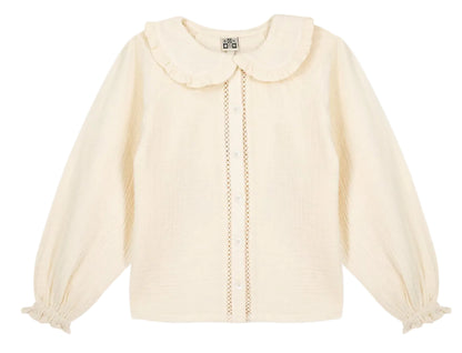 The Girls’ Figue Shirt by Bonton features a cream long-sleeve design with a ruffled Peter Pan collar, button-down front, pleated texture, and lace trim detail.