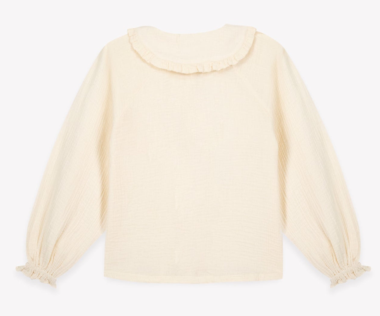 The Girls’ Figue Shirt by Bonton is a long-sleeve cream blouse featuring a delicate Peter Pan collar and ruffled cuffs, crafted from 100% cotton, and displayed flat on a plain white background.