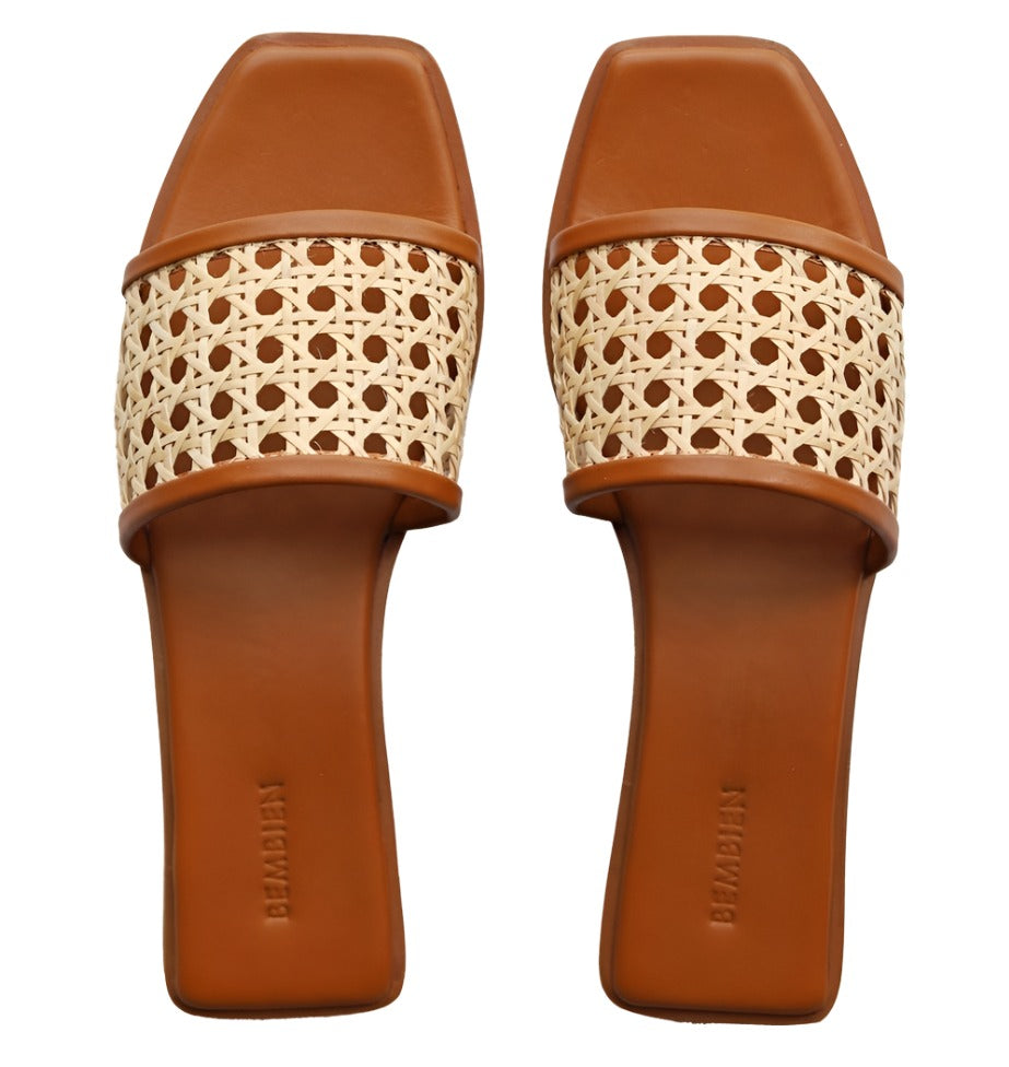 Bembien Pia Slide by Bembien showcases two brown flat sandals with square toes and handwoven beige leather straps, handmade in India.