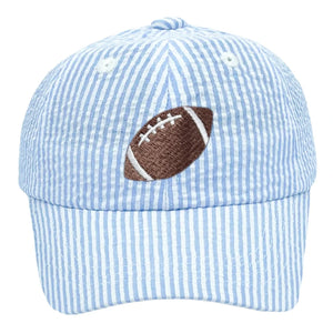Add a sporty touch to your look with the Bits & Bows Blue Seersucker Football Baseball Hat, featuring light blue and white stripes and an embroidered brown football on the front.