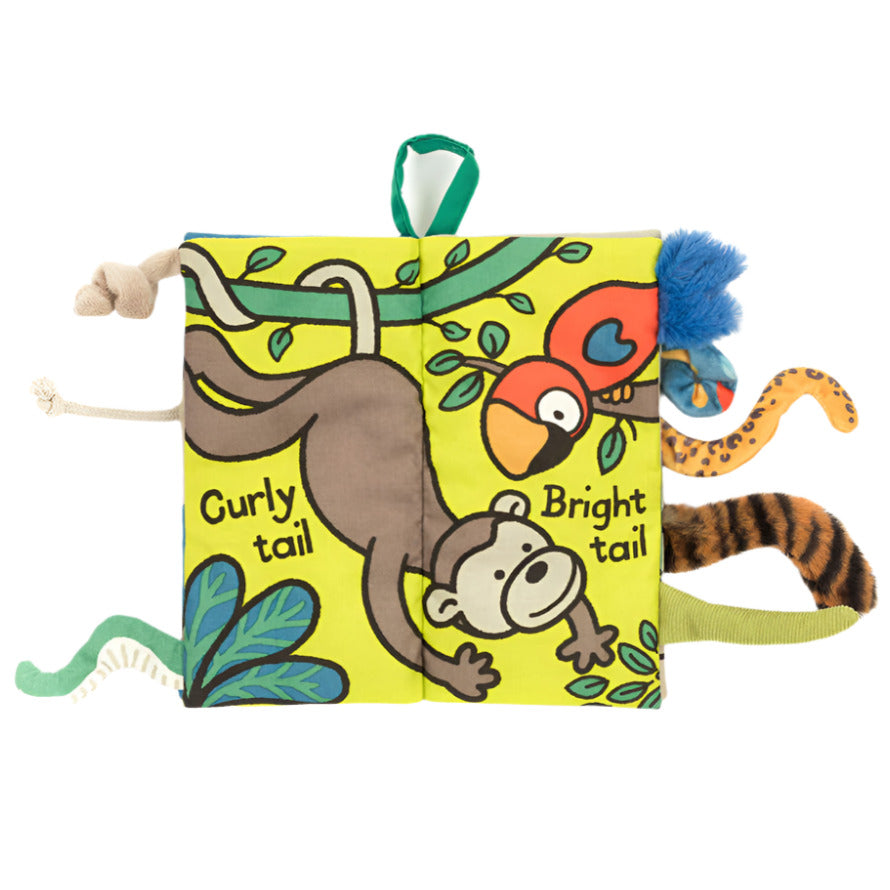 The Jungly Tails Activity Book by Jellycat is a soft, touch-and-feel cloth book featuring jungle animal illustrations like a monkey and parrot, with textured tails labeled "Curly tail" and "Bright tail" sticking out from the sides.