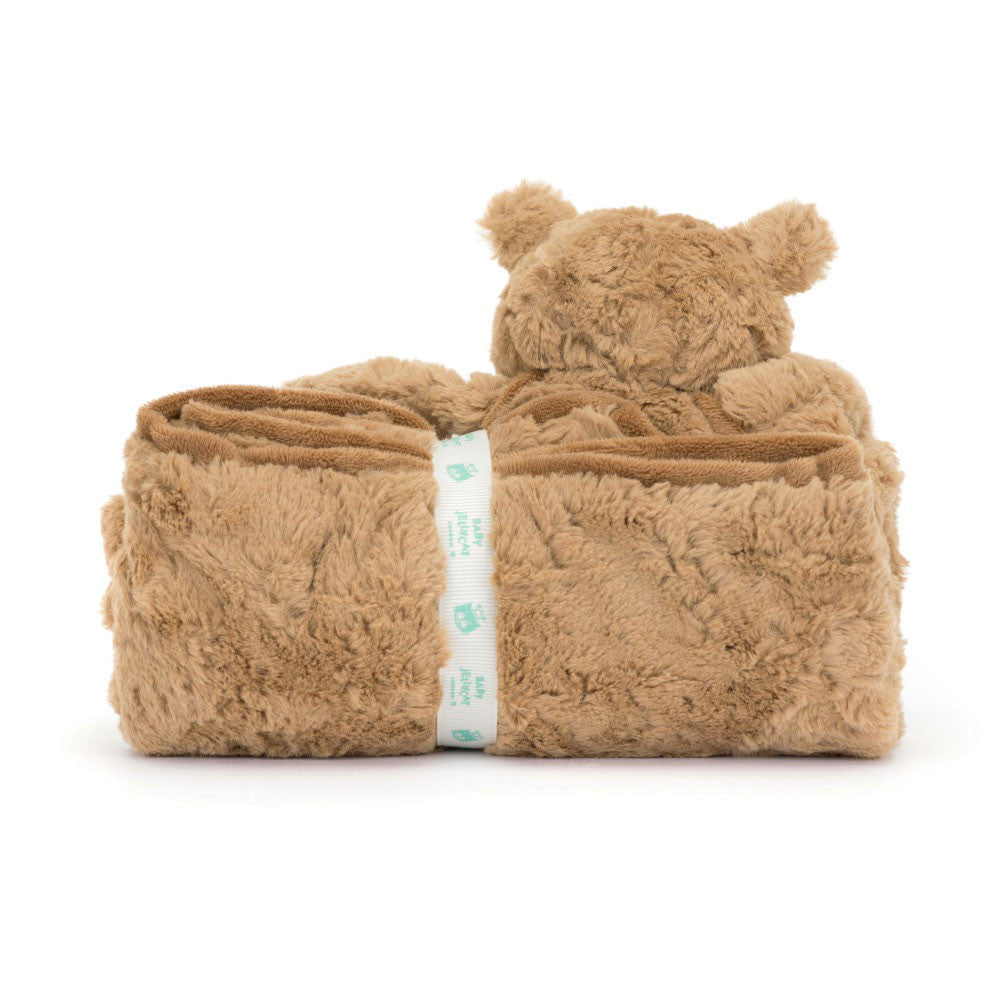 A plush, brown Jellycat Bartholomew Bear Blankie folded neatly, with a beige strap around it displaying small blue bear icons.