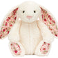 Plush white bunny with pink floral-patterned inner ears and feet, sitting upright and facing forward—this charming Blossom Cream Bunny ‘Berry’ by Jellycat closely resembles a classic cream Berry Bunny.