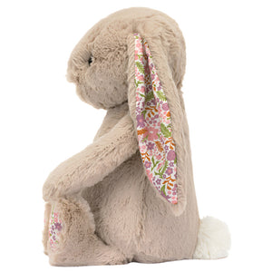 Side view of the Jellycat Blossom Beige Bunny 'Petal' Small with bashful beige fur and floral-patterned inner ears, sitting upright.