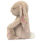 Blossom Beige Bunny 'Petal' by Jellycat sits upright in profile, with wildflower-print inner ears and paws plus a white fluffy tail—an adorable member of the Jellycat Garden Club bunny plush collection.