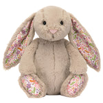 The Jellycat Blossom Beige Bunny 'Petal' Small, a design by Jellycat, features bashful beige fur with floral-patterned inner ears and paws, sitting upright and facing forward.