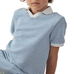 A child is seated facing forward, wearing the Gingersnaps Boys' Husker Striped Terry Shirt, a blue and white polo with a white collar and cuffs.