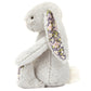 The Jellycat Blossom Silver Bunny 'Bloom' Small, by Jellycat, is a plush gray bunny with floral-patterned inner ears and paws, sitting upright, and featuring charming Bashful fur.