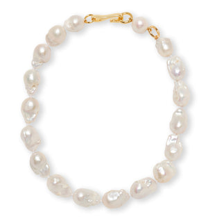 The Claude Necklace by Lizzie Fortunato showcases baroque pearls and a gold-plated brass clasp, beautifully arranged in a circle on a white background.