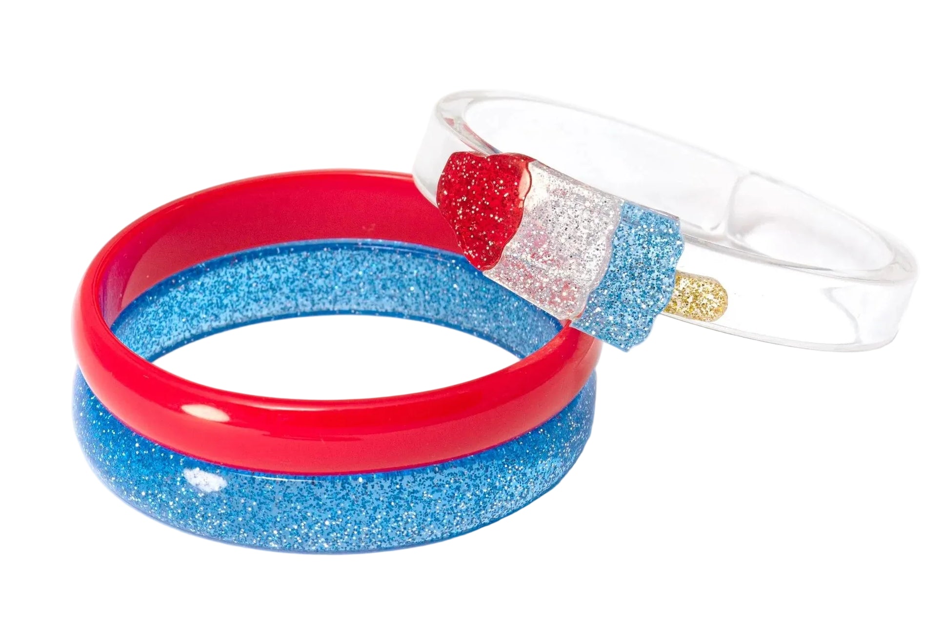 The Lillies & Roses Popsicle Rocket Glitter Red Blue Bangles set features three playful bracelets: one red, one blue with glitter, and one clear with a glittery red, white, and blue popsicle—ideal festive patriotic jewelry.