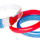 The Lillies & Roses Popsicle Rocket Glitter Red Blue Bangles set includes three plastic bangles—one clear with a popsicle design, one red, and one blue with glitter—for a playful patriotic accessory.
