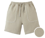 Gingersnaps Boys' Marlow Textured Drawstring Shorts in beige cotton-linen feature two front pockets with white zigzag stitching, shown close-up to highlight the unique fabric texture.