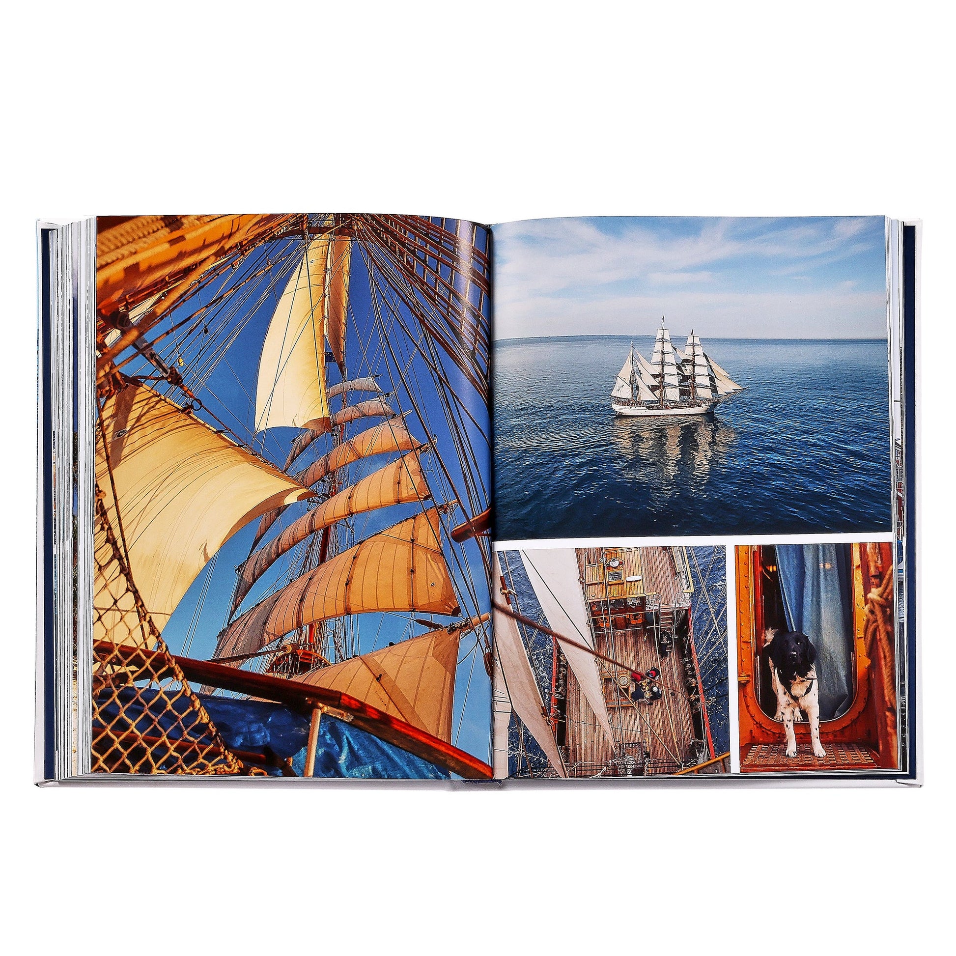 The open photo book "Boatlife: Exploring the Freedom of Maritime Living" by Graphic Image displays images of a tall ship at sea, its sails, rigging, crew on deck, and a dog—reflecting maritime adventure and nomadic living.