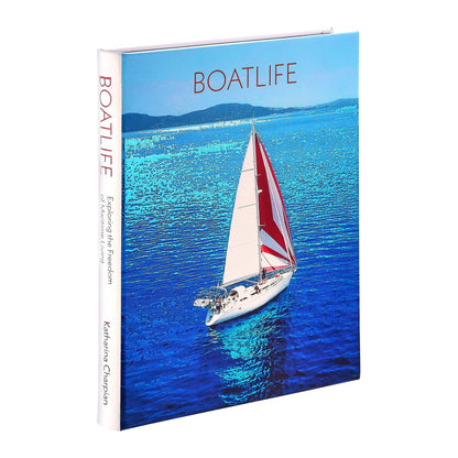 Boatlife: Exploring the Freedom of Maritime Living" by Graphic Image features a sailboat with a red and white sail on blue water, evoking freedom and adventure in an alternative, nomadic lifestyle.