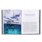 An open book from Graphic Image’s "Boatlife: Exploring the Freedom of Maritime Living" shows a sailboat above water and two divers below, beside an article on humpback whales, highlighting the allure of maritime adventure living.