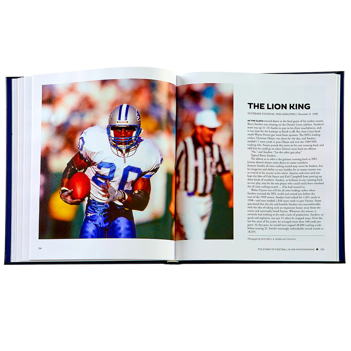 An open "The Story of Football Leather Book" by Graphic Image features an image of a football player holding a ball on the left, echoing the style of legendary coach Vince Lombardi, and text titled "The Lion King" on the right.