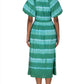 A person wearing a green and blue striped Banjanan Francesca Dress with short sleeves, seen from the back. The midi length dress has a cinched waist and falls below the knees. The person is also wearing brown sandals.